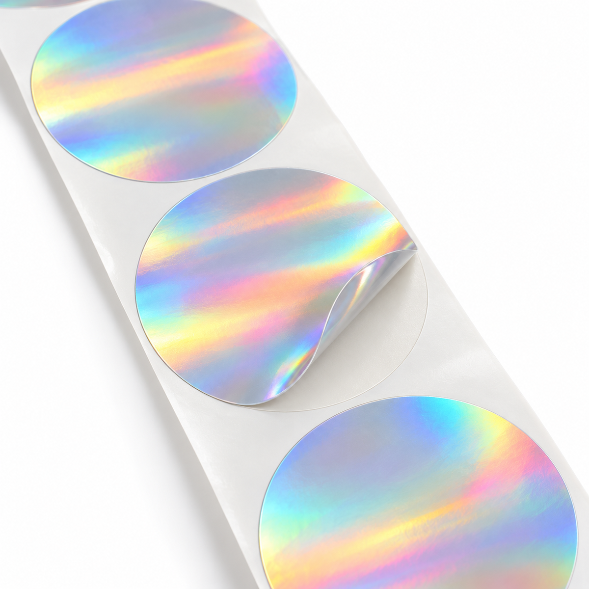 Close-up of blank holographic round labels with one edge lifted from the liner
